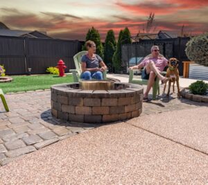 man and woman sitting on back patio with dog comfortably